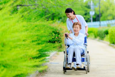 elderly woman on a wheelchair with her caregiver